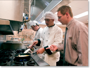 A teacher visits a WBL training site where student chefs are working